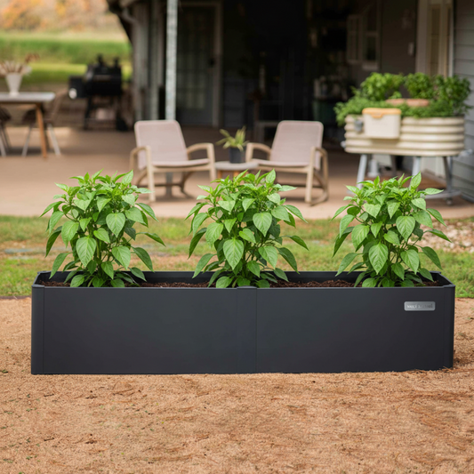17″ Tall Modern Garden Bed Extension Kit 41″ Long in Midnight Blue added to a compatible raised garden bed in a backyard setting.