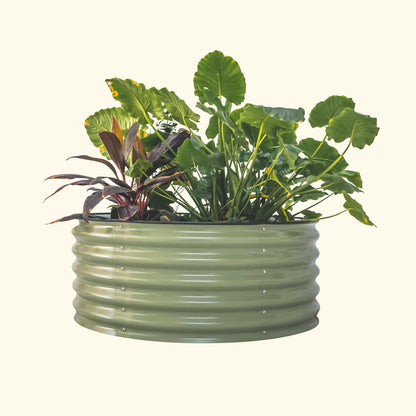 An olive green 42 inch round metal raised garden bed with colorful flowers and plants on a white background.