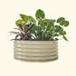 A pearl white 42 inch round metal raised garden bed with colorful flowers and plants on a white background