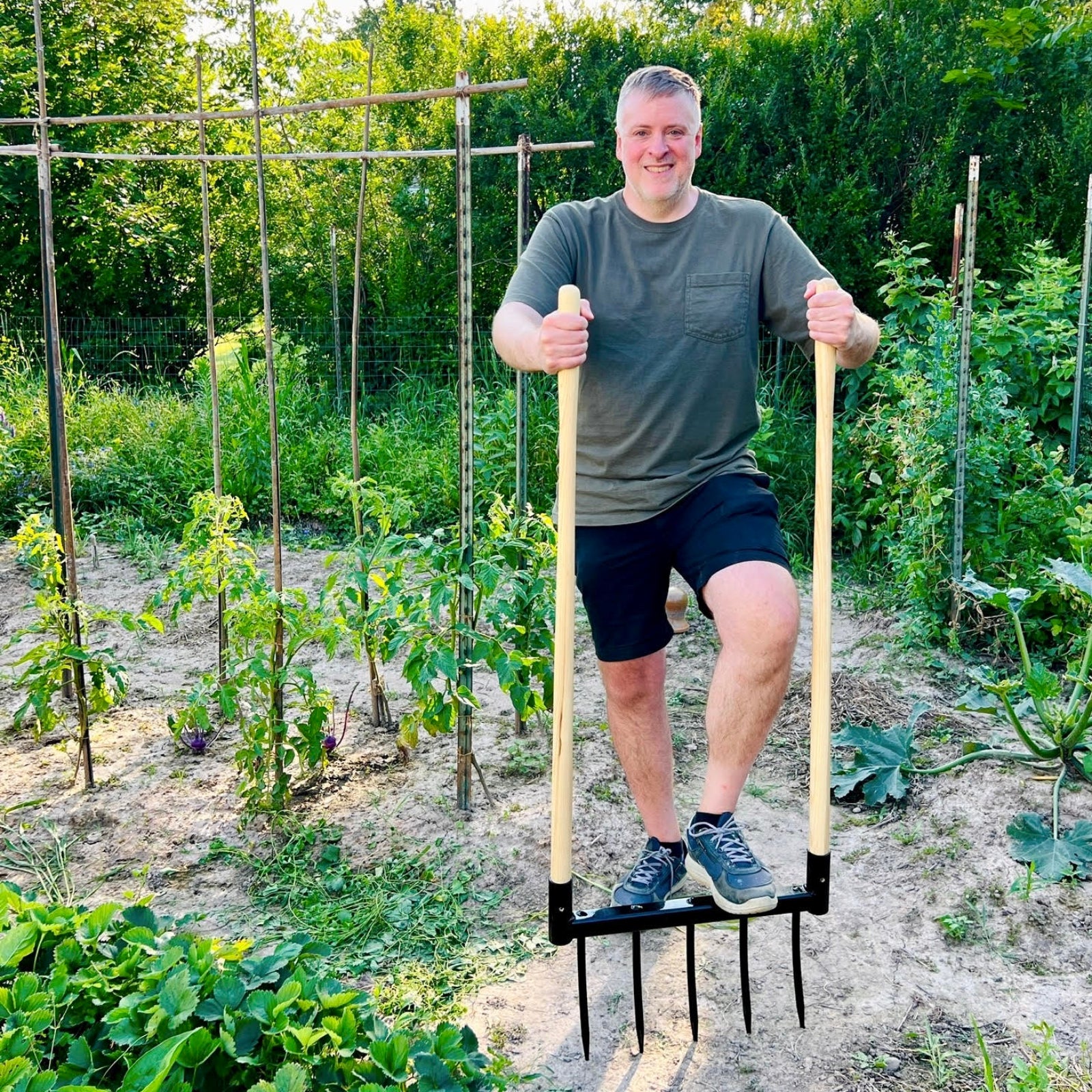 Man using a Braodfork Garden Tool for no-till soil aeration and cultivation in a garden