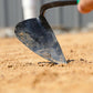 Person using the EZ-Digger Korean triangle blade tool in soil