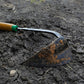 Close up of dirt on the EZ-Digger Korean triangle blade tool in use in a garden