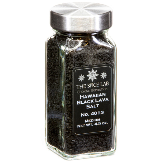A glass spice jar filled with black lava salt, featuring a silver metal lid and a black label with white text that reads 'THE SPICE LAB HAWAIIAN BLACK LAVA SALT'.