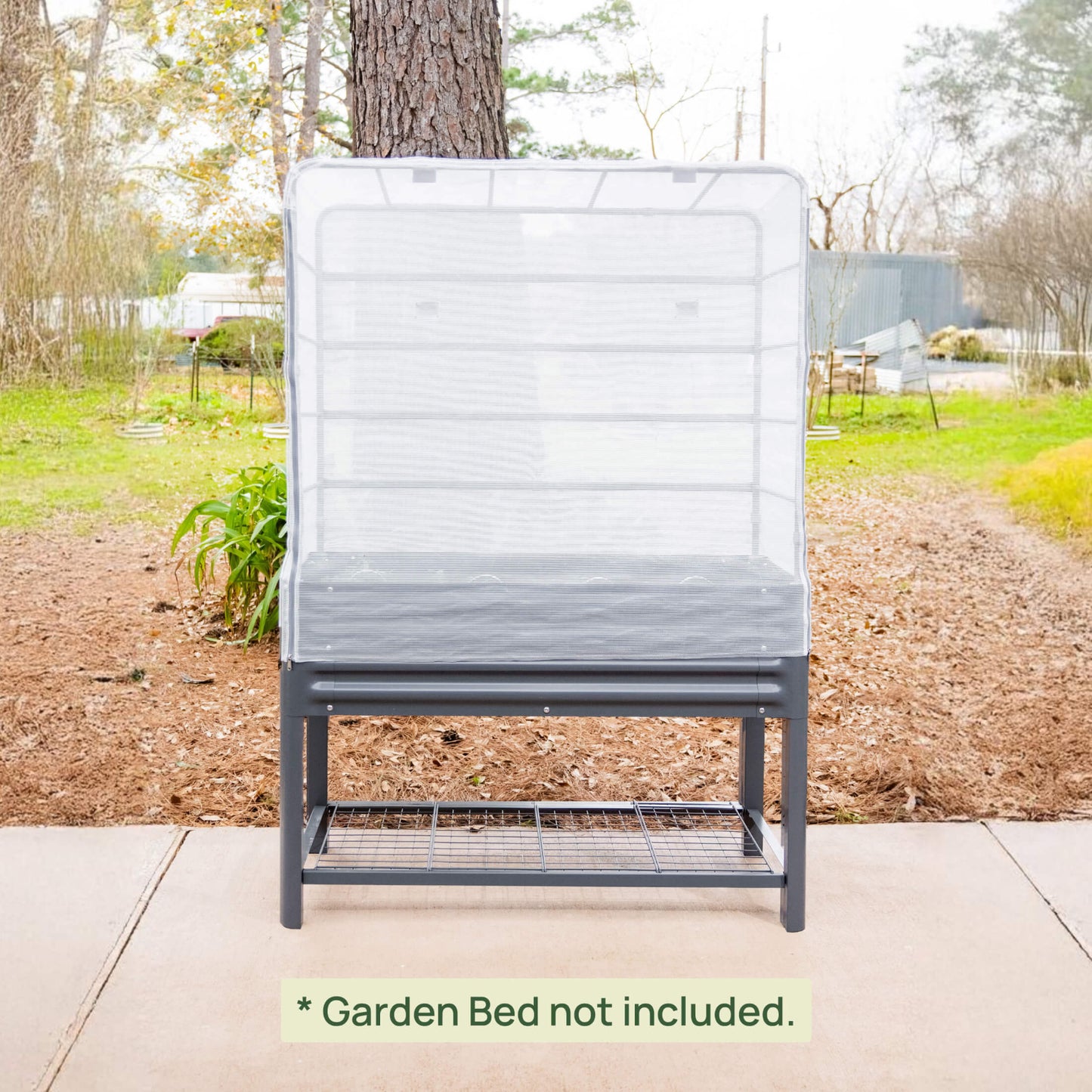 Gray metal garden bed with mesh cover in a garden setting with text clarifying the garden bed is not included.