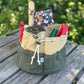 Green fabric tool roll with tools on a wooden surface outdoors