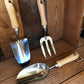Set of gardening tools with wooden handles on a wooden surface