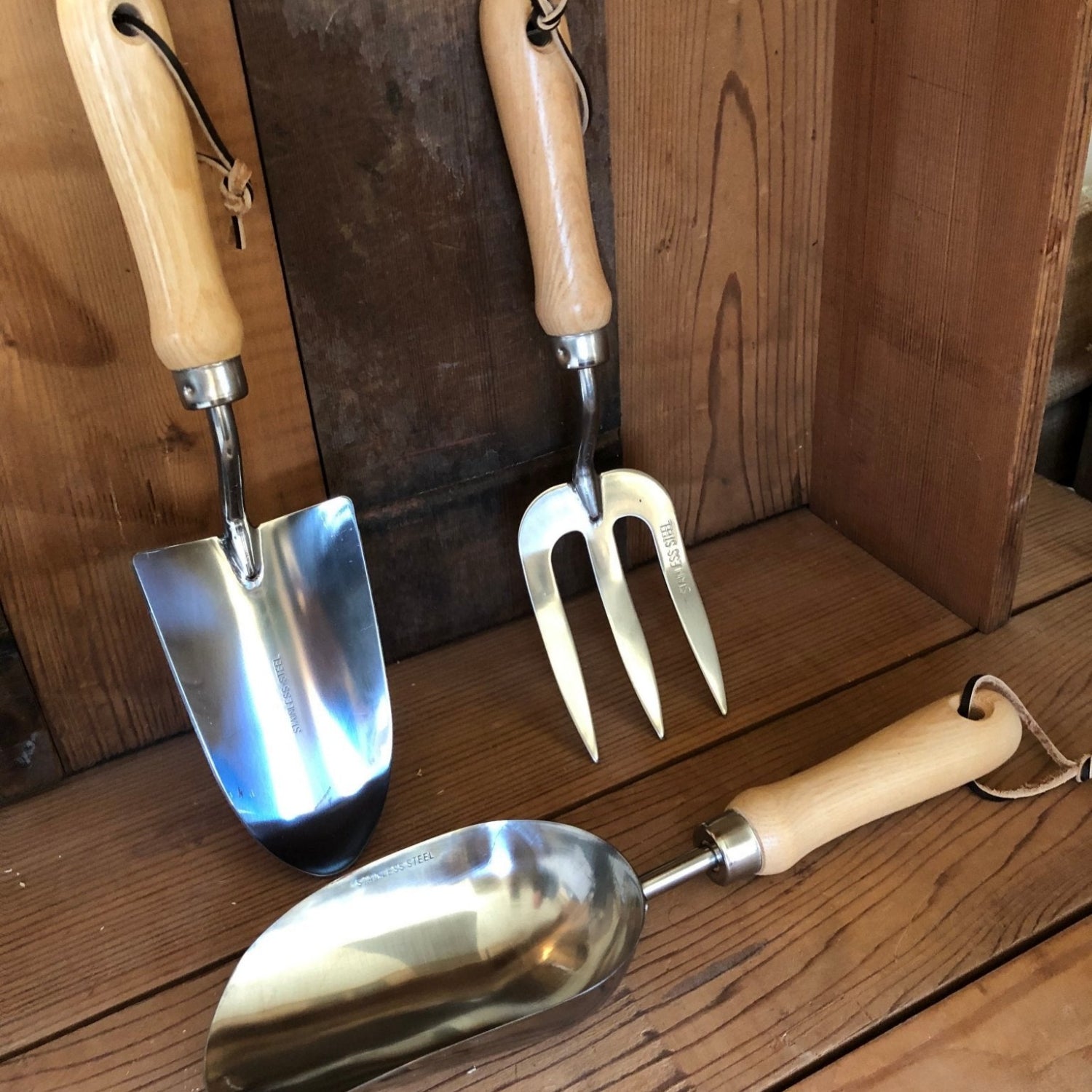 Set of gardening tools with wooden handles on a wooden surface