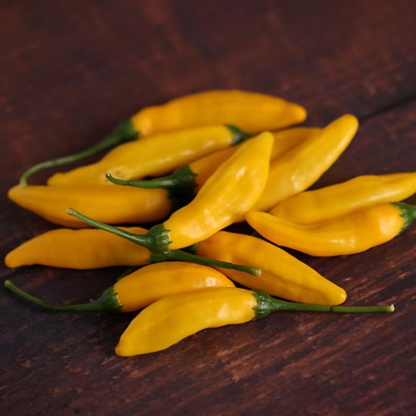 Pepper Joe's yellow lemon drop peppers piled on wood table used to represent seeds for sale